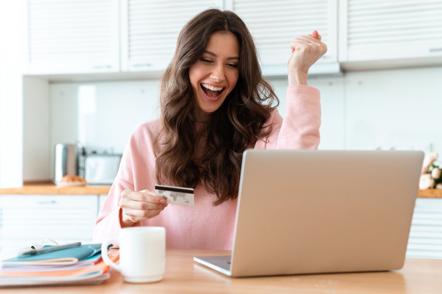 Woman Holding Credit Card Looking at Laptop